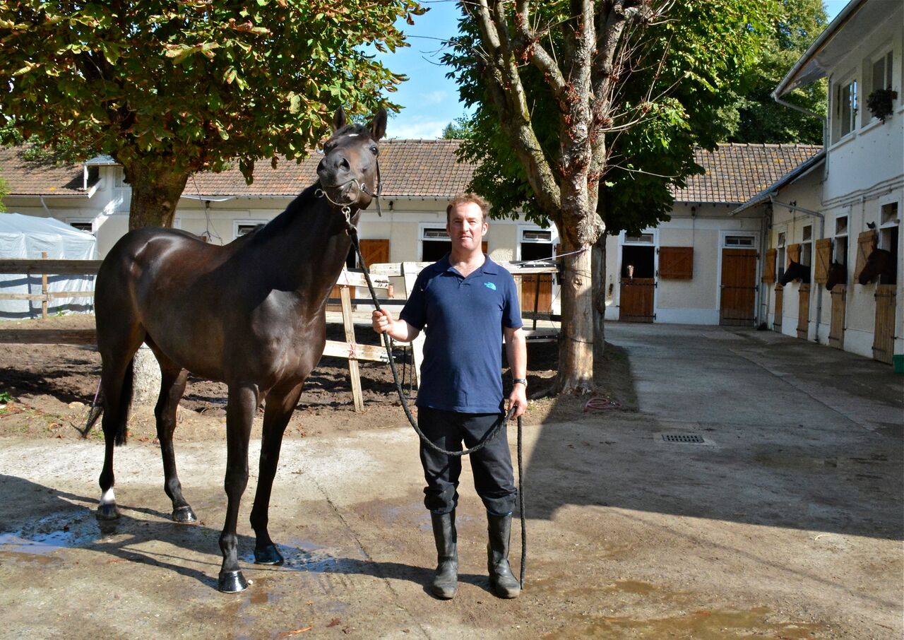 Andrew Hpllinshead with Flying Cape at his rented stables in Lamorlaye. “We love the lifestyle here in France,” he says. Photo: Alex Cairns (www.winningpost.net); Twitter: @ACHorseRacing; Instagram @the_winning_post