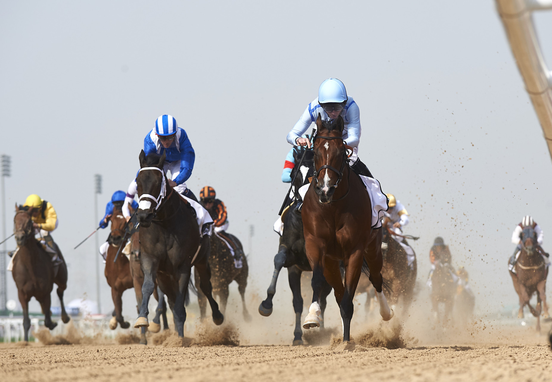 Ryan Moore (pale blue cap) took Heavy Metal into the lead soon after the gate opened in the Godolphin Mile, stuck to the inside and never looked like being beaten. Photo: Dubai Racing Club/Andrew Watkins