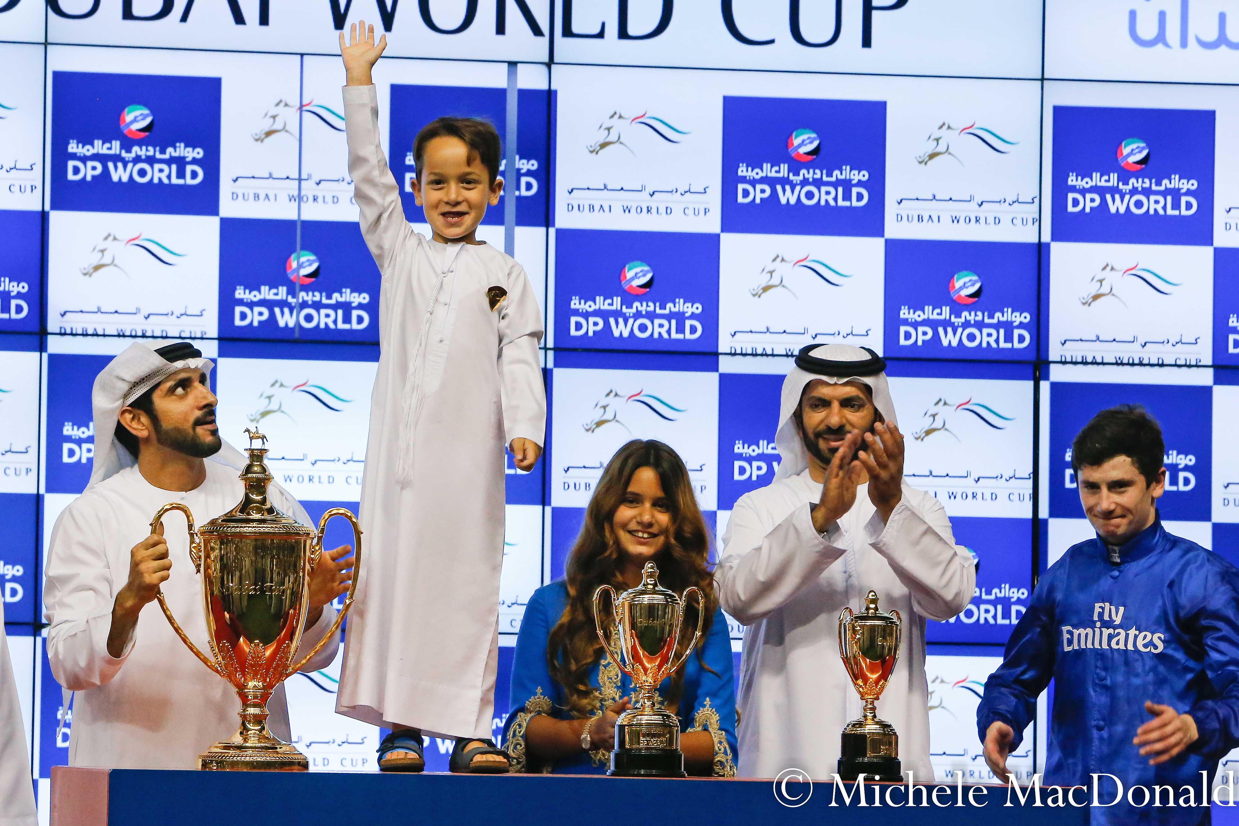 Benbatl’s Dubai Turf was the first of two huge wins on the night for Saeed Bin Suroor’s team. Here with the trophy are Crown Prince Sheikh Hamdan bin Mohammed al Maktoum with the young son of Sheikh Mohammed and Princess Haya, Sheikh Zayed, standing on the table next to their daughter, Al Jalila, and Saeed Bin Suroor and  jockey Oisin Murphy. Photo: Michele MacDonald