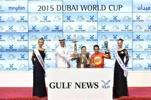 Dana Barnes & Victor Espinoza accept the trophy for the G1 Dubai Golden Shaheen at Meydan. Photo: Dubai Racing Club/Andrew Watkins
