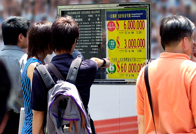 People outside a betting center in Hong Kong to buy Mark Six Lottery tickets. Photo: AP Photo/Lo Sai Hung.