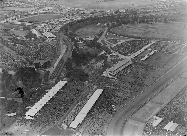 Flemington aerial view circa 1930, showing the Hill Stand and Bagot's Cowshed in the foreground and the 1924 Members' Stand beyond. Photo via State Library of Victoria.