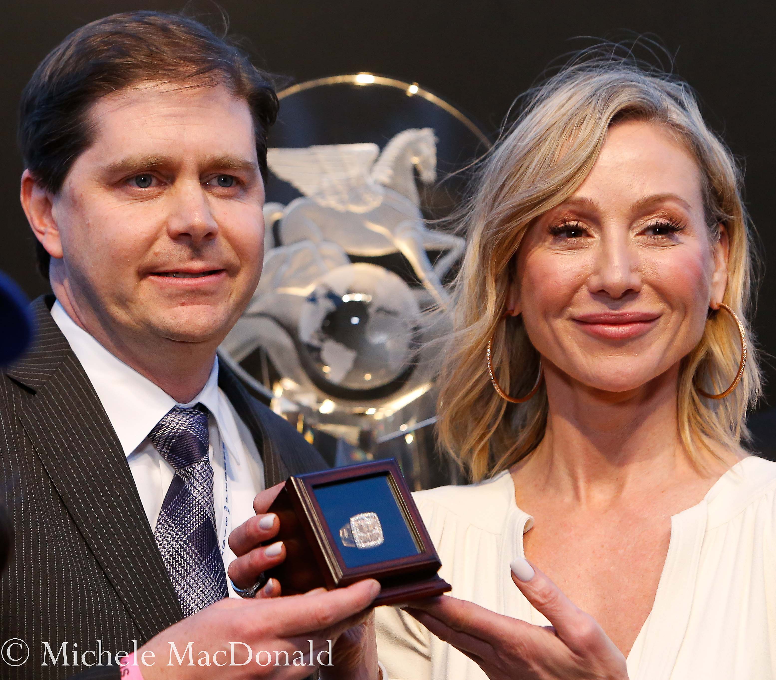 Presentation time: part owner Ron Winchell and Belinda Stronach display the winner’s gold ring in front of the main Pegasus trophy. Photo: Michele MacDonald