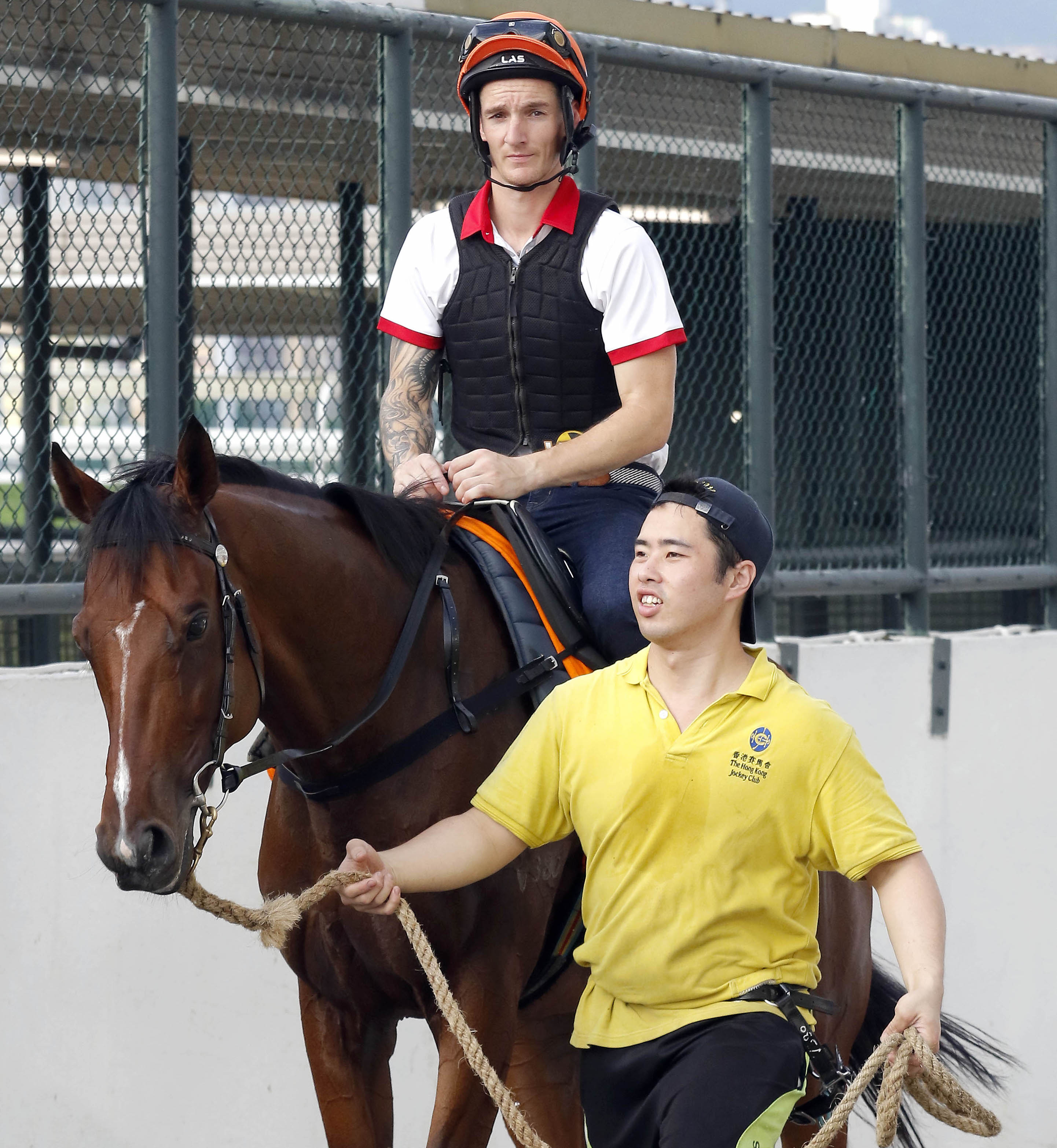 Groom Lau Wai-kit leads Beauty Generation and Romain Clavreul out to work. Photo: Hong Kong Jockey Club