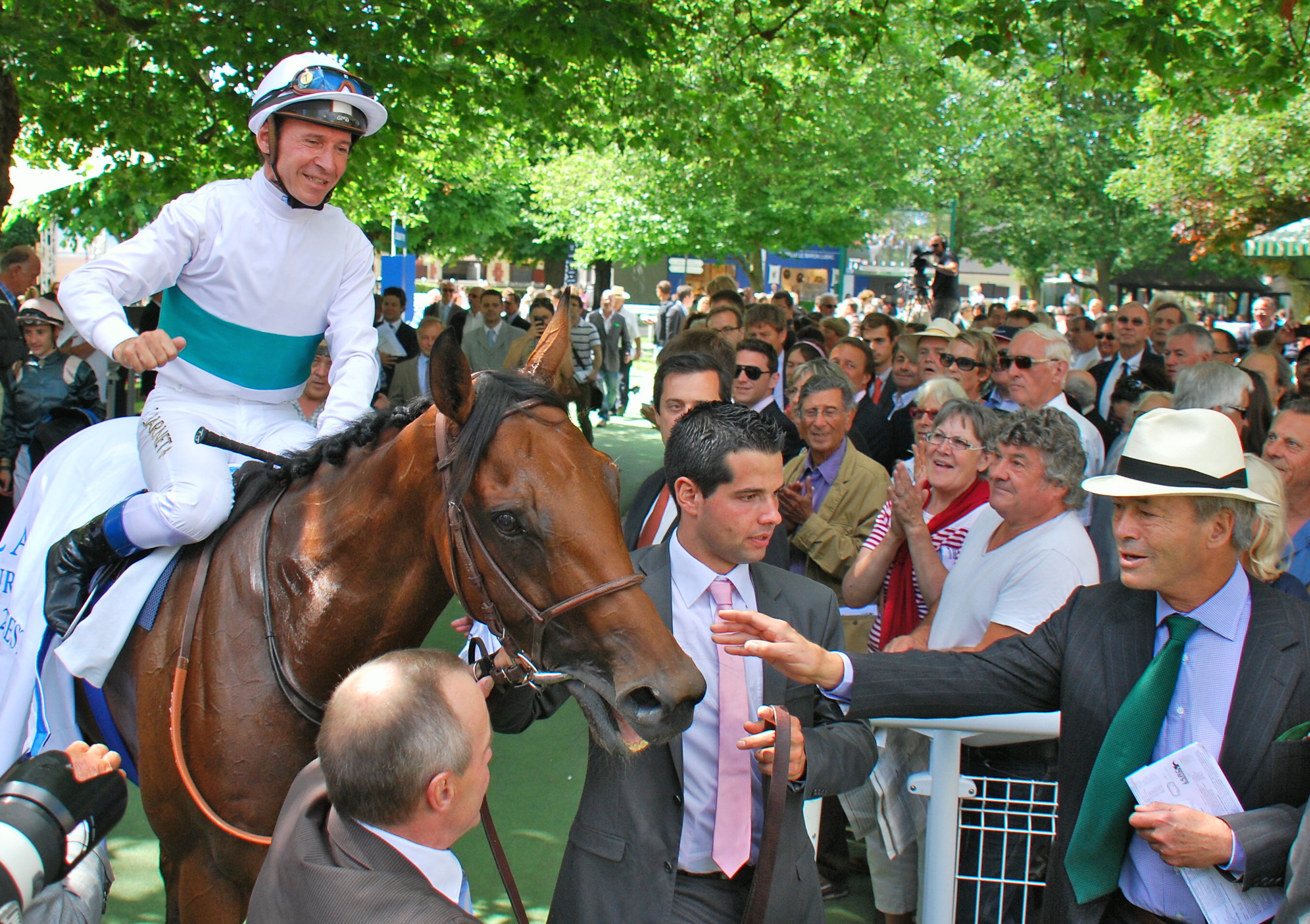 Pride and joy: George Strawbridge (straw hat, right) greets his Moonlight Cloud (Thierry Jarnet) after the mare’s win in the 2013 Prix Maurice de Gheest at Deauville. Photo: John Gilmore