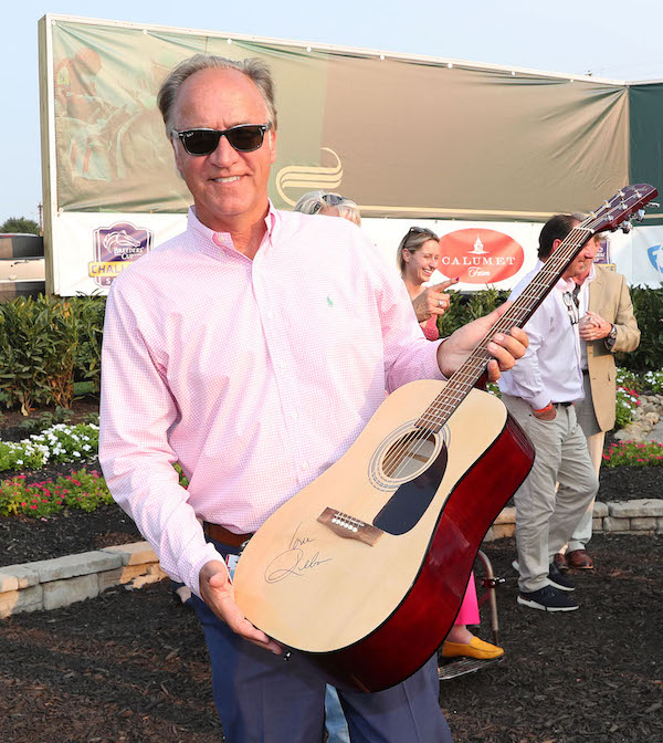 Guitar hero: Ted Nicholson, Kentucky Downs’ vice president for racing, holds the Reba McEntire-signed guitar that served as a trophy for one of last year’s G2 events. Photo: Jennie Rees