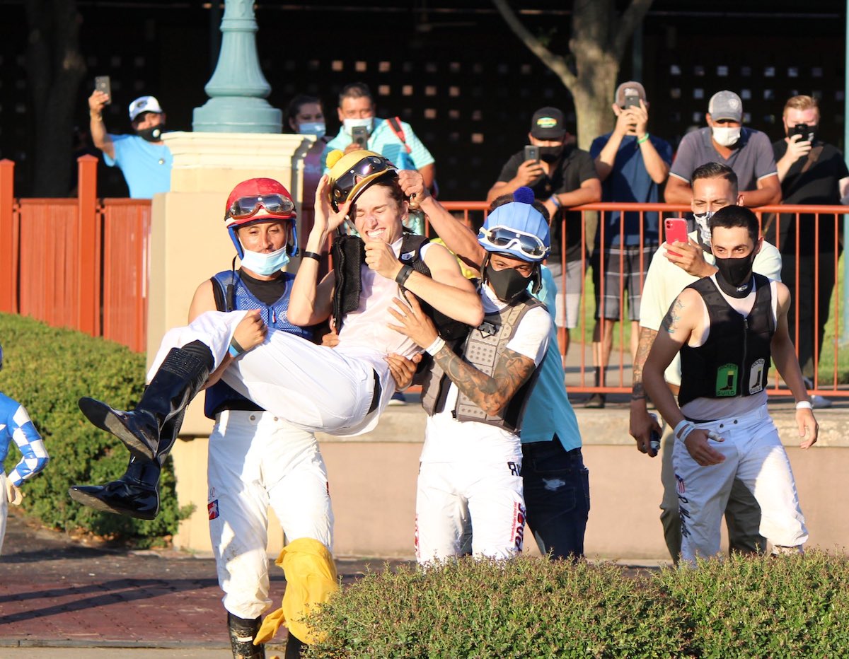Time for a soak: fellow jockeys prepare to dump Keith Asmussen in the fountain after his first winner – as per racetrack tradition at Lone Star Park. Photo: Lone Star