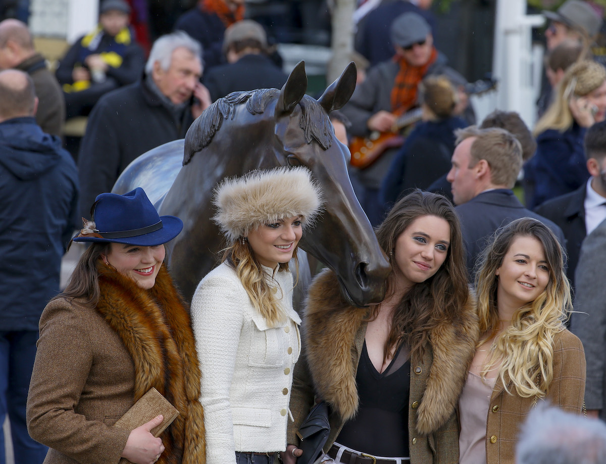 Racegoers pose alongside the Best Mate statue at Cheltenham. Photo: Mark Cranham / focusonracing.com 