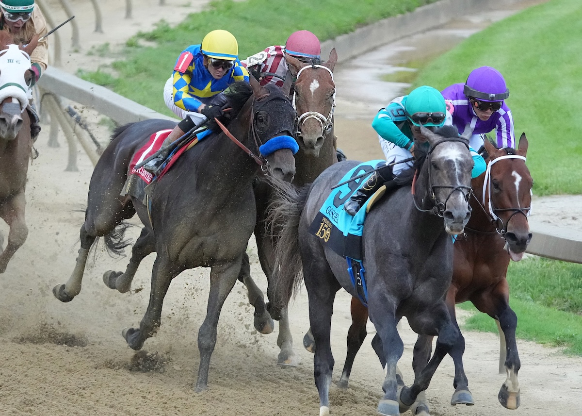 Rough ride: Journalism (red cap, rails) boxed in at Pimlico. Photo: Maryland Jockey Club